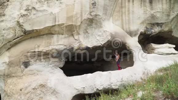 女旅行者穿过洞穴洞穴城附近的巴希萨拉伊托普凯门克里米亚的景点慢动作视频的预览图