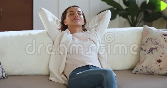 慵懒的年轻女子慵懒地靠在舒适的沙发上视频的预览图
