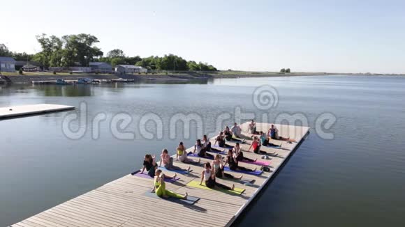 早上一群人在湖边的码头上做瑜伽视频的预览图