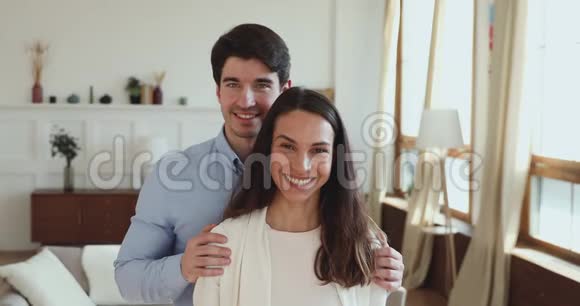 一对幸福的年轻夫妇拿着钥匙站在新公寓里视频的预览图