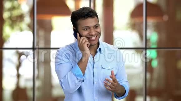 快乐的情感棕色皮肤的男人在餐馆打电话视频的预览图