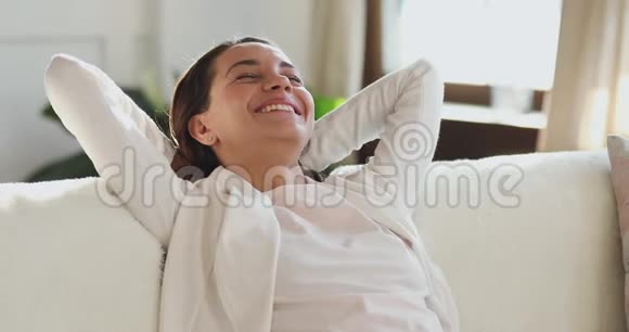 漂亮快乐的年轻女人在客厅沙发上放松视频的预览图