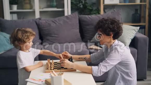 幸福的家庭母子在家下棋把棋子搬上船视频的预览图