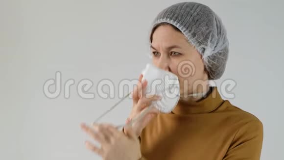 女性佩戴一次性杯子和过滤口罩呼吸器用于白色背景下的污染和个人保护视频的预览图