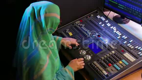 戴眼镜的穆斯林妇女一个照明设计师为一个节目制作灯光视频的预览图
