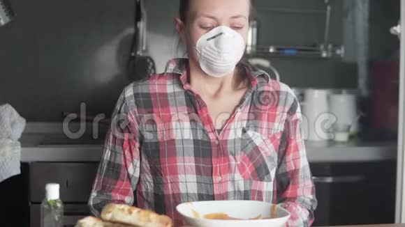 这名妇女在进食前将口罩从脸上移开用防腐剂处理她的手视频的预览图