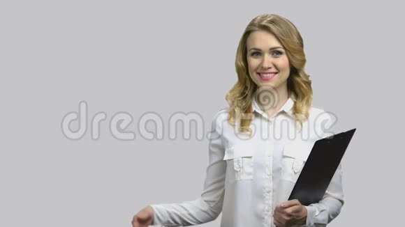 快乐的年轻女人用剪贴板举起她的右掌视频的预览图