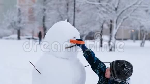 冬季雪天有雪人的孩子圣诞节假期视频的预览图