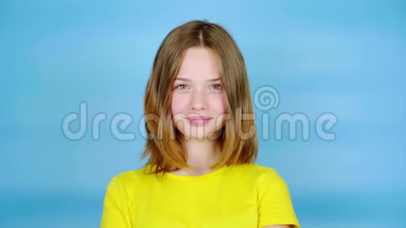 穿黄色T恤的快乐少女微笑着看着镜头视频的预览图