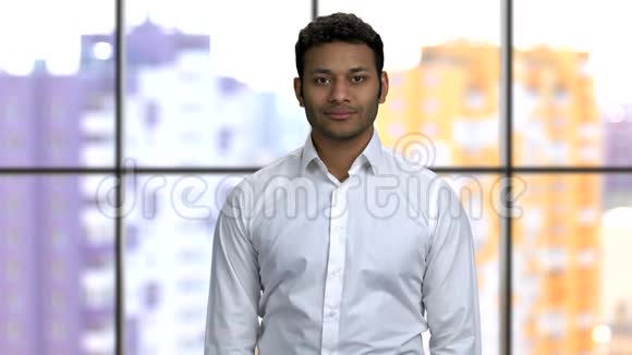 一个年轻快乐的印度教男子穿白色正式衬衫的肖像视频的预览图