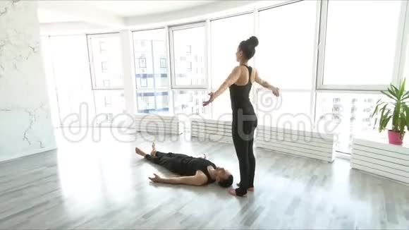 一对年轻夫妇在工作室里做杂技瑜伽视频的预览图