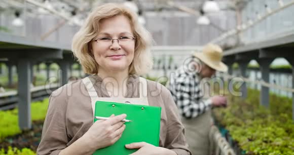 一位戴眼镜的高白种人微笑的女士的特写镜头看着镜头他是男性职业农学家视频的预览图