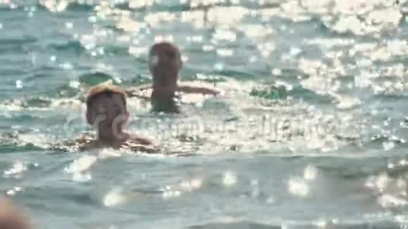 爸爸和儿子在海里游泳和玩耍他们休息享受生活慢动作视频的预览图