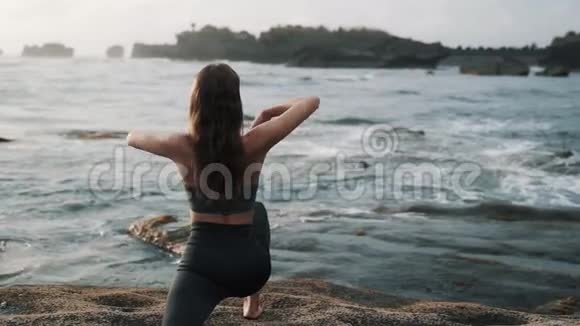 女孩站在石头上与海浪搏斗视频的预览图