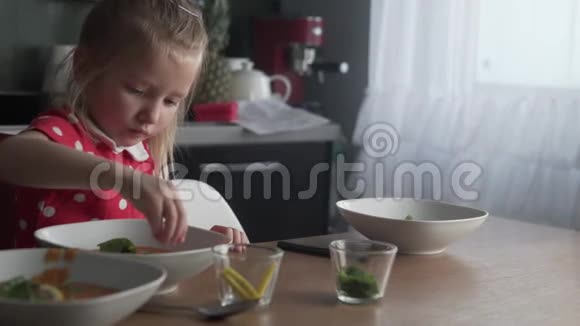 一个小女孩用薄荷和柠檬装饰蔬菜汤视频的预览图