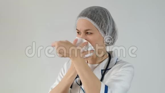 女医生佩戴一次性杯子和过滤口罩呼吸器以防止白色背景污染视频的预览图