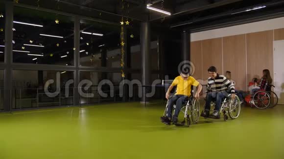 快乐的少年男孩在轮椅上快乐的赛车视频的预览图