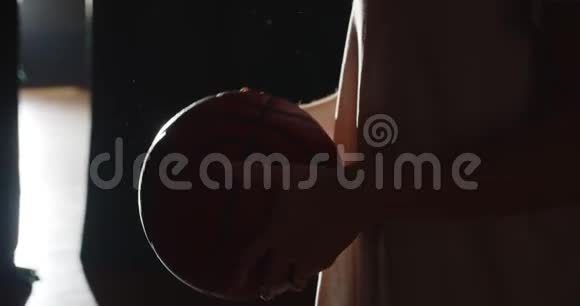 年轻的白种人篮球运动员准备去后台黑暗剪影光线自信球视频的预览图