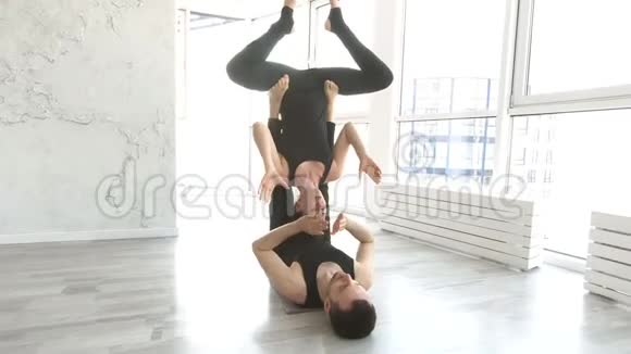 积极的女性与男伴一起练习杂技瑜伽视频的预览图