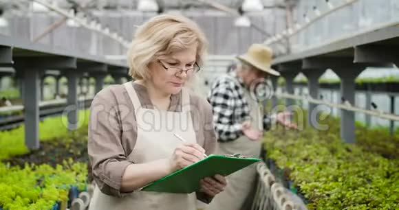 专业白种人女性农艺师在眼镜上的肖像标志着植物的生长好女人视频的预览图