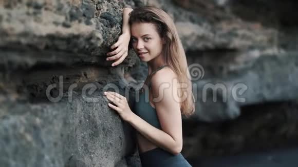 女孩的姿势是相机靠在悬崖和调整头发视频的预览图