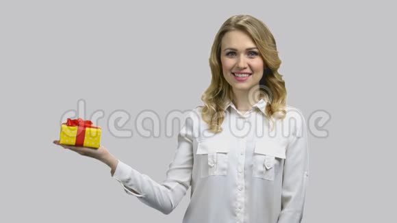 年轻快乐的女人右手拿着礼物盒视频的预览图