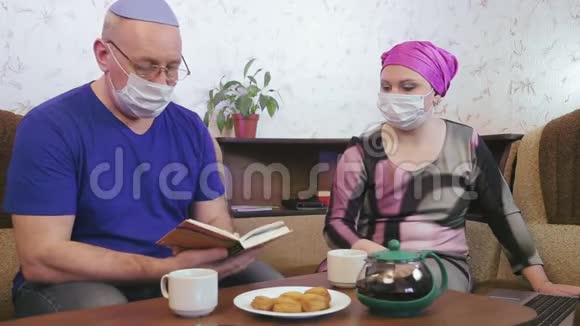 犹太已婚夫妇戴着防护面具在家中被隔离以防止睡椅上的冠状病毒视频的预览图