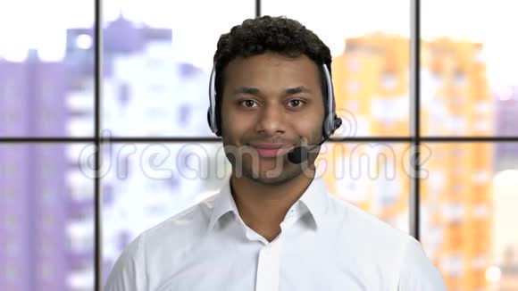 一个年轻的深色皮肤的家伙戴着耳机带着牙齿微笑的肖像视频的预览图