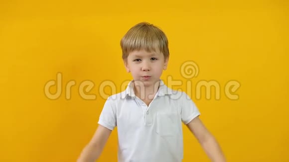 闭上金发男孩交叉双臂在黄色背景下显示停止禁忌禁止视频的预览图