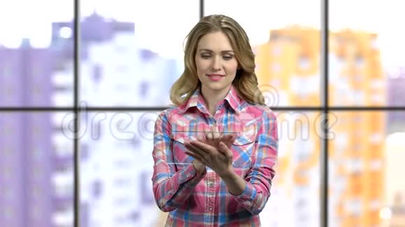 年轻女孩触摸和放大透明平板电脑视频的预览图