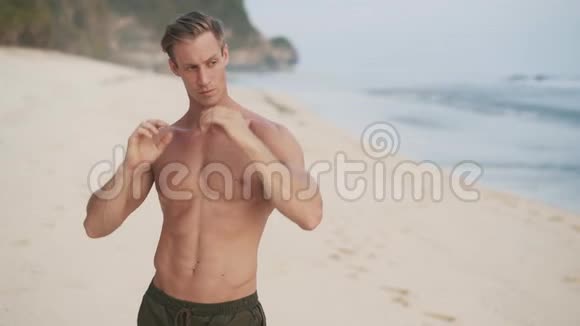 男子在沙滩上展示肌肉身体的镜头视频的预览图