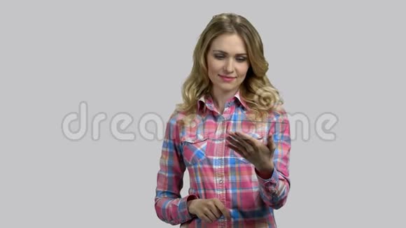 年轻女子贴着空白的玻璃平板电脑在网上和某人交谈视频的预览图