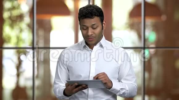 印度教一个年轻人举着平板电脑发表演讲的肖像视频的预览图