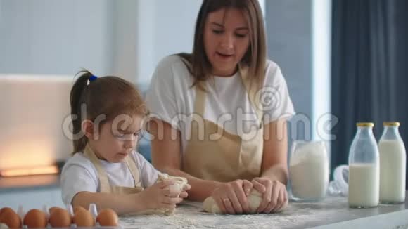 母亲和女儿在厨房用面团模具做饭母女俩抱着心形面团模具把它刻下来视频的预览图