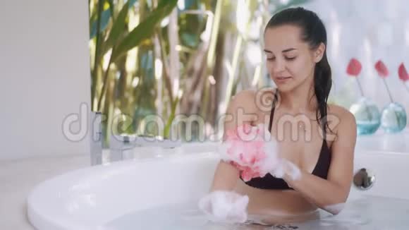 穿比基尼的女孩在房间里用植物洗澡视频的预览图
