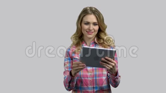 快乐的年轻女人开始使用她的平板电脑在线交谈视频的预览图