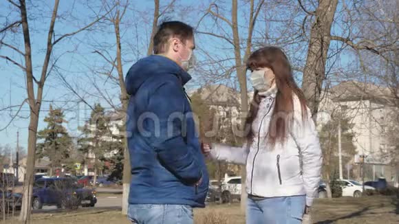 男人和一个戴着防病毒和细菌保护面具的女人在街上交谈大流行冠状病毒游客视频的预览图
