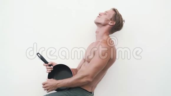 穿着平底锅的性感男人用她的吉他弹搞笑视频视频的预览图