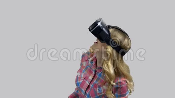 相当漂亮的兴奋女人在VR耳机抬头和挥动手臂视频的预览图