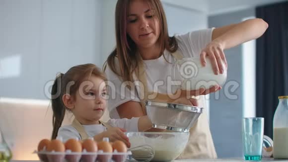 女人和女孩在厨房里扔鸡蛋女儿和母亲一起做饭视频的预览图