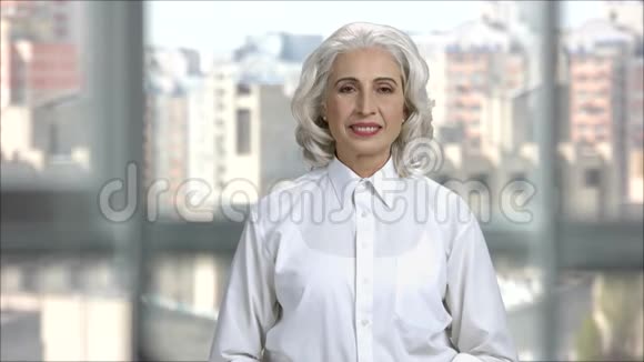 微笑的高级女士穿着白色衬衫手势确定标志视频的预览图