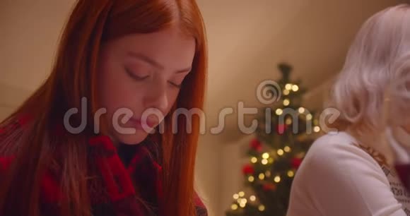 红发少女祖母晚餐圣诞树傍晚安慰家人视频的预览图