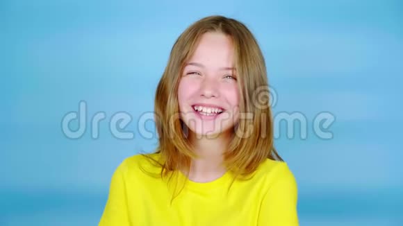 穿黄色T恤的快乐少女正在笑着看着镜头视频的预览图