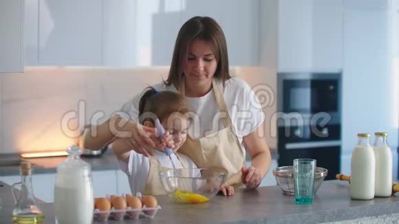 妈妈教女儿用搅拌器打面团做馅饼爱的母女一起做馅饼妈妈视频的预览图