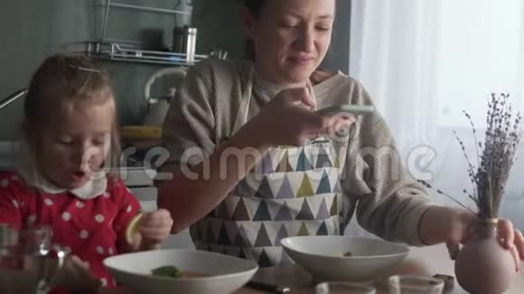 一个女人在午餐时用手机拍下她的食物视频的预览图