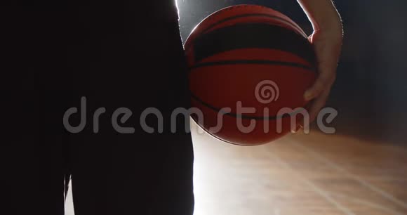 篮球运动员举着一个球的特写明亮的光影轮廓视频的预览图