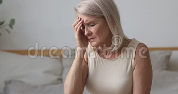 精疲力竭的老年成熟妇女患有强烈的头痛视频的预览图