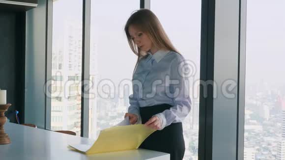 办公室文件夹里的女商人窗户附近有文件视频的预览图