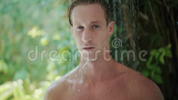 年轻人在绿色热带植物附近洗澡视频的预览图