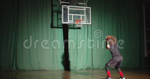 Curly篮球运动员看着篮子拿着球准备自信扔球得分绿色背景视频的预览图